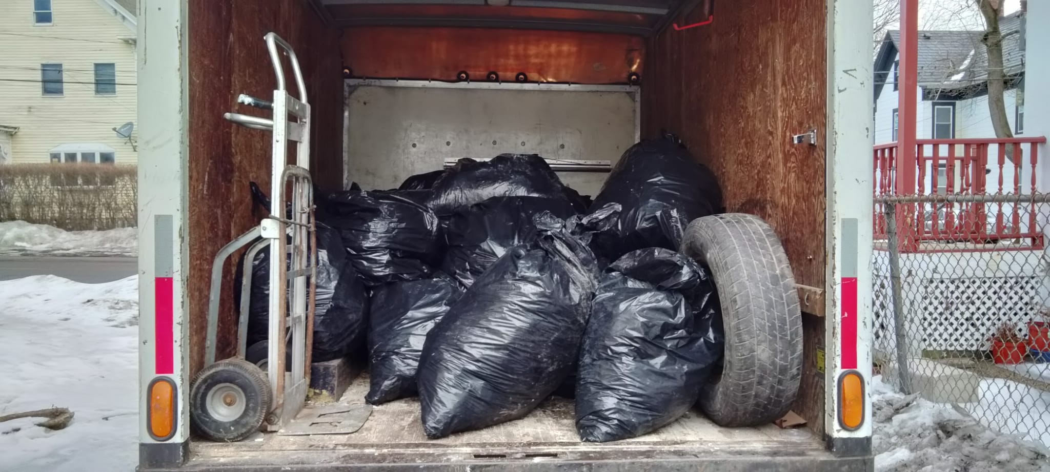Box truck full of bagged trash and tires